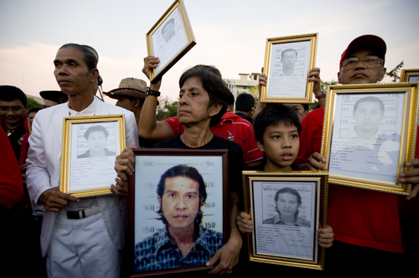 Mourners carry photographs of people killed in a Bangkok massacre - Thailand